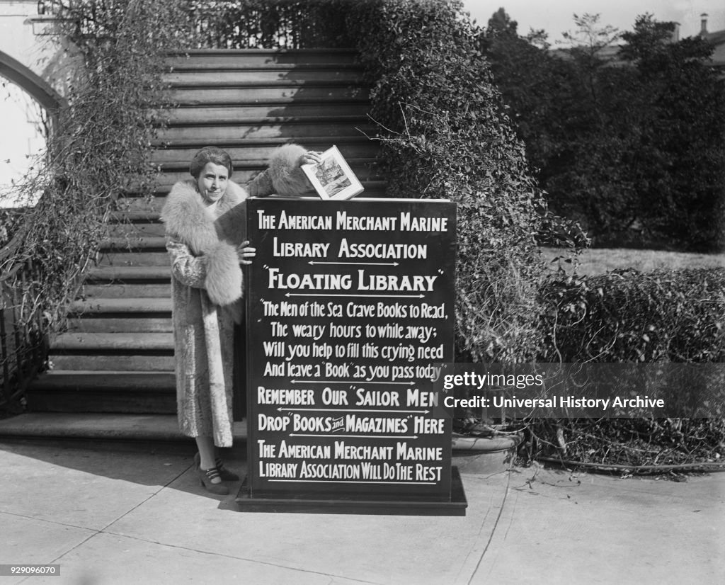 First Lady Grace Coolidge Dropping First Book into Box That Started Drive by American Merchant Marine Library Association for "Floating Library" for Sailors, Washington DC, USA, Harris & Ewing, January 1929