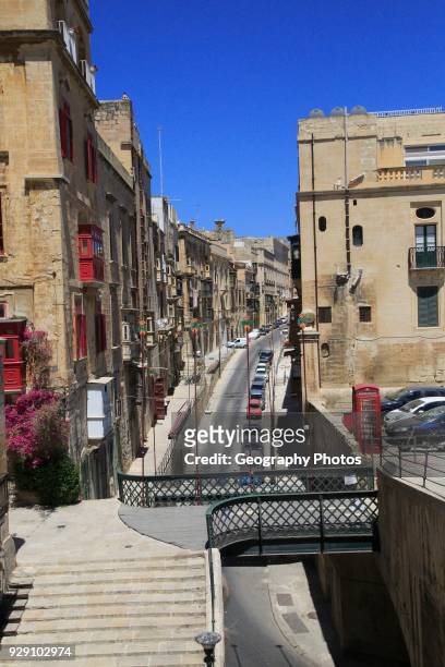 Historic buildings red telephone box iron bridge in city center of Valletta, Malta.
