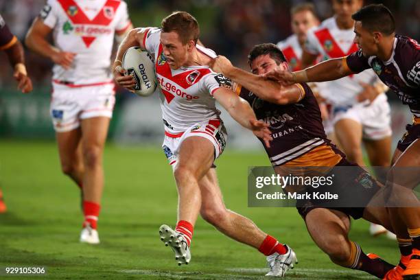 Cameron McInnes of the Dragons is tackled by Matt Gillett of the Broncos during the round one NRL match between the St George Illawarra Dragons and...