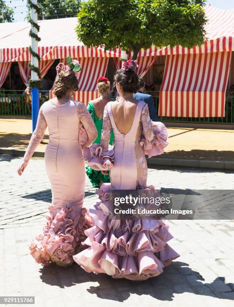 Seville, Seville Province, Andalusia, southern Spain, Feria de Abril, the April Fair, Young women wearing flamenco dresses.