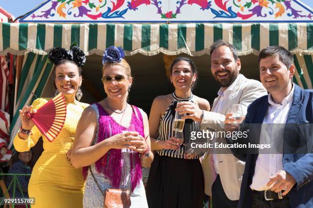 Seville, Seville Province, Andalusia, southern Spain, Feria de Abril, the April Fair, Group of happy friends raise their glasses.