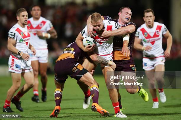 Jack De Belin of the Dragons is tackled by Matthew Lodge of the Broncos during the round one NRL match between the St George Illawarra Dragons and...