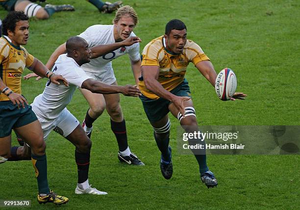 Wycliff Palu of Australia offloads as Ugo Monye of England closes in during the Investec Challenge Series match between England and Australia at...