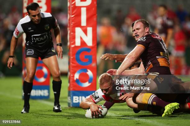 Jack De Belin of the Dragons beats Matthew Lodge of the Broncos to score a try during the round one NRL match between the St George Illawarra Dragons...