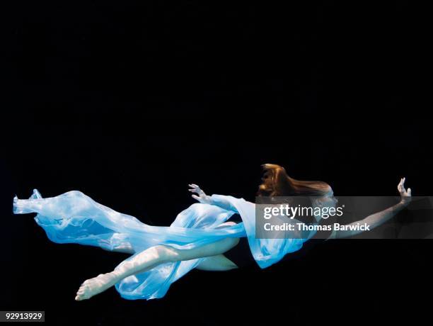 female dancer underwater against black background - leotard stockfoto's en -beelden