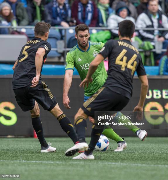 Will Bruin of the Seattle Sounders tries to dribble through Dejan Jakovic of Los Angeles FC and Moutinho Joao of Los Angeles FC during a match at...