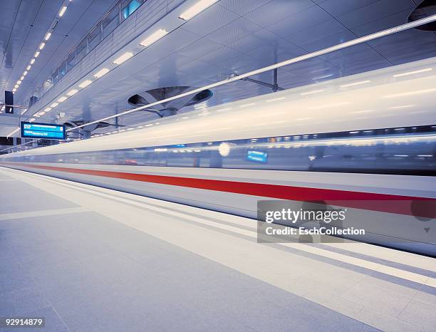 a fast ice train leaving berlin central station - berlin hauptbahnhof stock-fotos und bilder