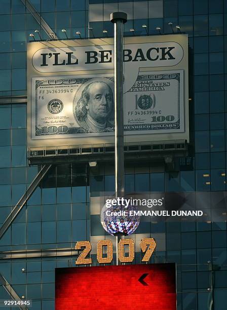 Billboard featuring a 100 US dollar bill saying "I'll be back", is seen over Times Squares' New Year ball in New York, November 09, 2009. The...