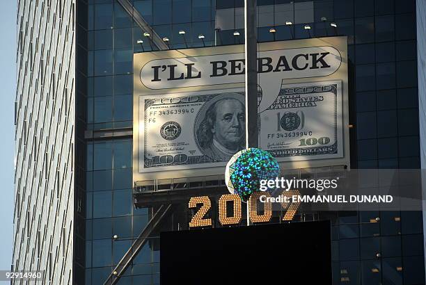 Billboard featuring a 100 US dollar bill saying "I'll be back", is seen over Times Squares' New Year ball in New York, November 09, 2009. The...