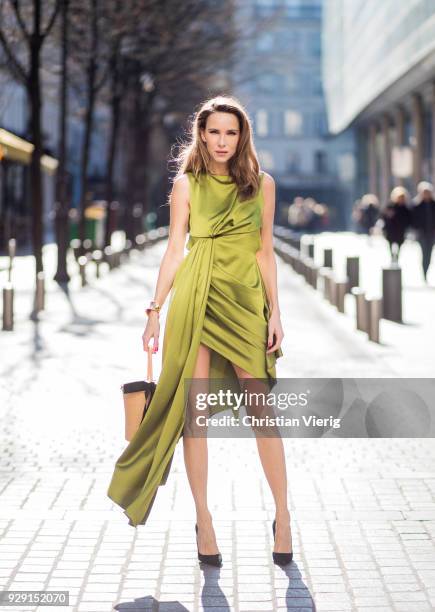 Alexandra Lapp is seen wearing an asymmetric layered silk dress from Off-white in green with a basket bag from Sensistudio with a black bow and black...