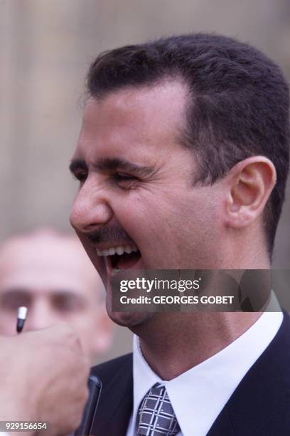 Bashar al-Assad, son of Syrian President Hafez al-Assad laughs 07 November 1999 in the courtyard of the Elysée Palace after his meeting with French...