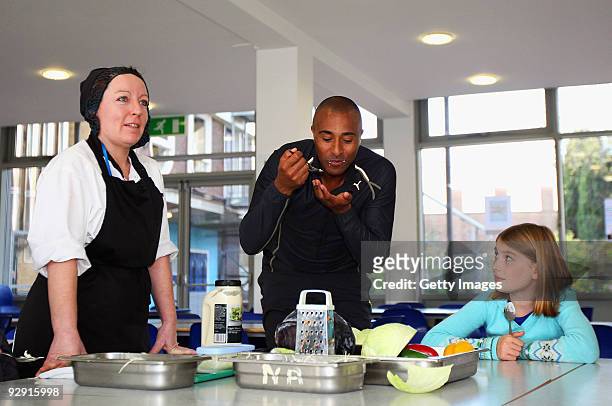 Colin Jackson OBE helps catering staff from Morpeth School make coleslaw at the Launch of National School Meal Week on November 9, 2009 in London,...