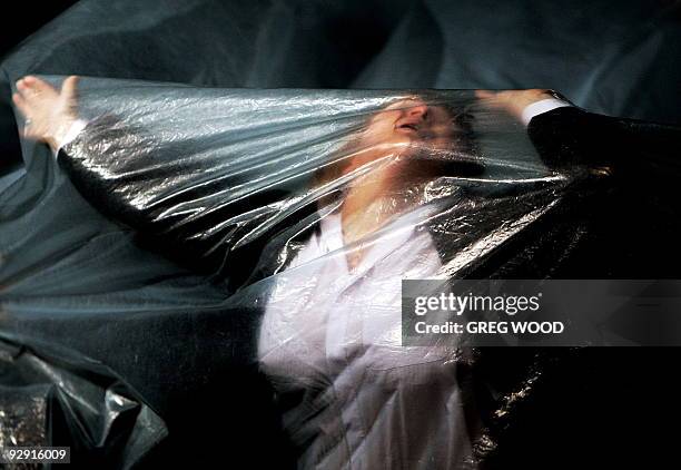 Performer from the Belarus Free Theatre rehearses underneath a sheet of plastic the production of "Being Harold Pinter" in Sydney on January 6, 2009....