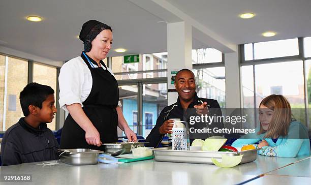 Colin Jackson OBE helps catering staff from Morpeth School make coleslaw at the Launch of National School Meal Week on November 9, 2009 in London,...