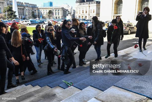 Women throw flowers on the steps of the Romanian Ministry of Interior during a protest against domestic violence on the International Women Day in...