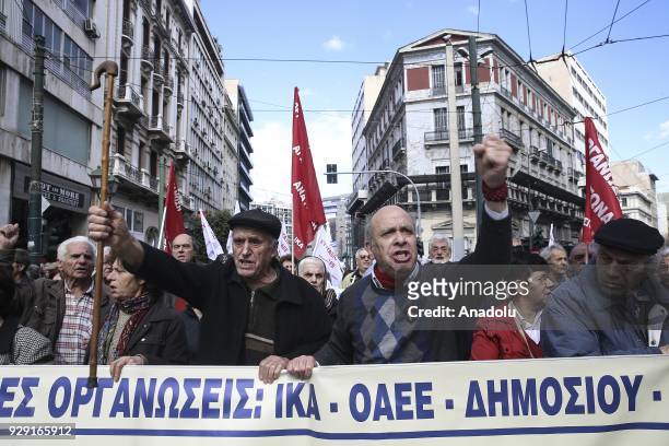 Greek retirees shout slogans as they hold a banner during a protest against pay cuts as they march from Kotzia Square to The Ministry of Labour,...
