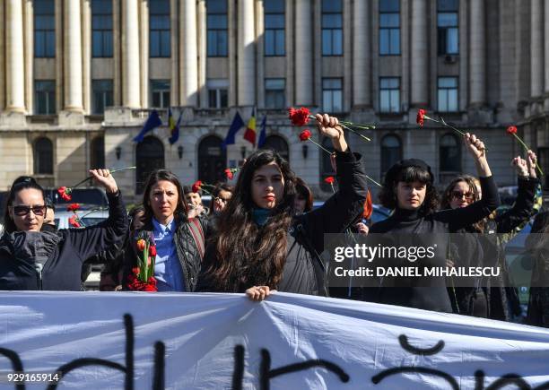 Women protest with flowers against domestic violence in front of the Romanian Ministry of Interior in Bucharest on March 8 the International Women...