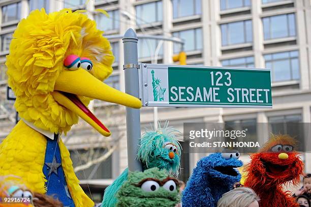 Big Bird and other Sesame Street puppet charactors pose next to temporarty street sign November 9, 2009 at West 64th Street and Broadway in New York...