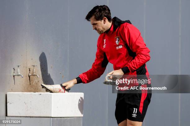 Charlie Daniels of Bournemouth cleans his boots during an AFC Bournemouth training session on March 7, 2018 in Bournemouth, England.