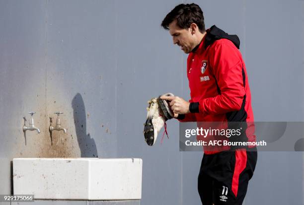 Charlie Daniels of Bournemouth cleans his boots during an AFC Bournemouth training session on March 7, 2018 in Bournemouth, England.