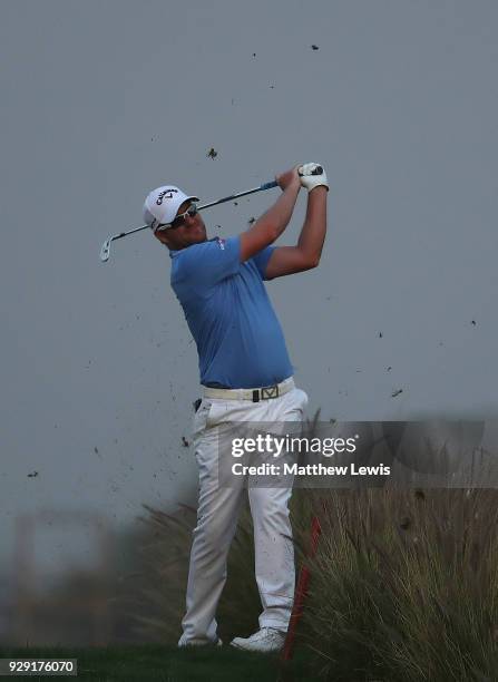 Marc Warren of Scotland plays hs second shot from the 18th fairway during day one of the Hero Indian Open at Dlf Golf and Country Club on March 8,...