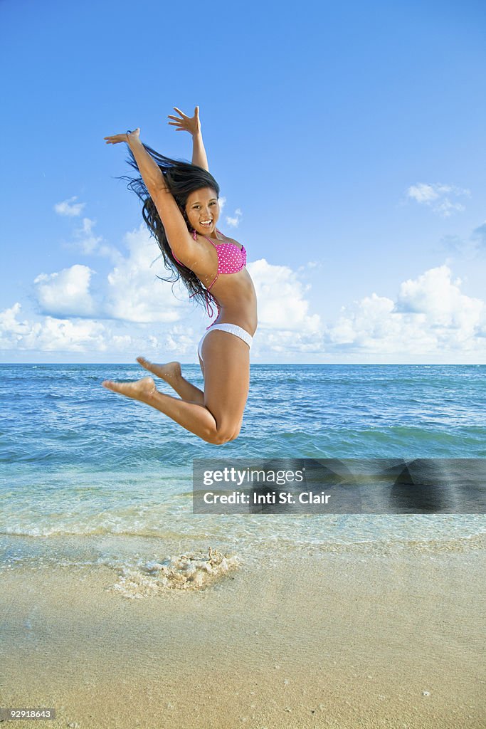 Woman jumping for joy at the beach/ocean