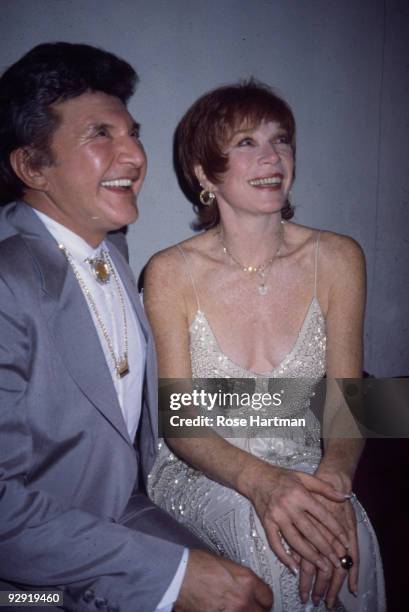 American pianist Liberace shares a laugh with actress Shirley MacLaine at the latter's 50th birthday party at the Limelight in New York City, New...