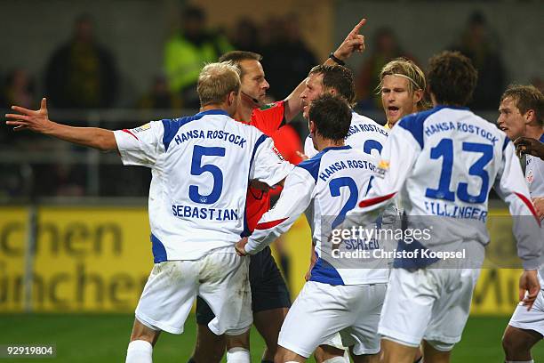 Referee Peter Gagelmann does not decide for a goal of Rostock and Tim Sebastian , Marcel Schied, Enrico Kern and Mario Fillinger of Rostock show...