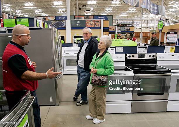 Sales specialist Aris Lizardo, left, helps customers Nancy Stainback, right, and her husband Boddy look at refrigerators at a Lowe's store in...