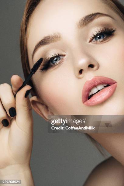beautiful woman applying mascara - eyebrow beauty stock pictures, royalty-free photos & images