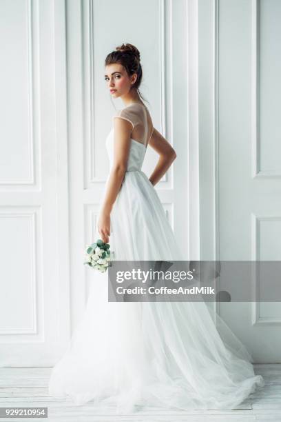 mooie brunette vrouw als bruid met bruiloft boeket - bridal styles stockfoto's en -beelden