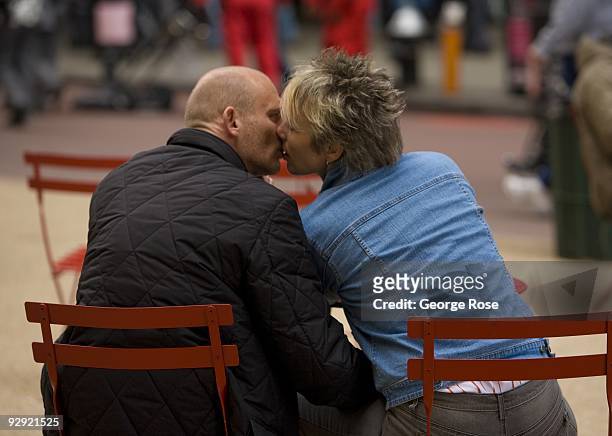 Couple in Times Square share a kiss while relaxing in the new pedestrian median as seen in this 2009 New York, NY, early evening cityscape photo.