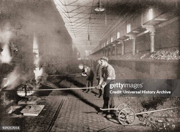 Drawing retorts by hand in the South Metropolitan Gas Company, London, England in the late 19th century. The retorts were where coal was heated to...