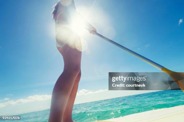 woman paddling on a stand up paddleboard. - paddleboarding australia stock pictures, royalty-free photos & images