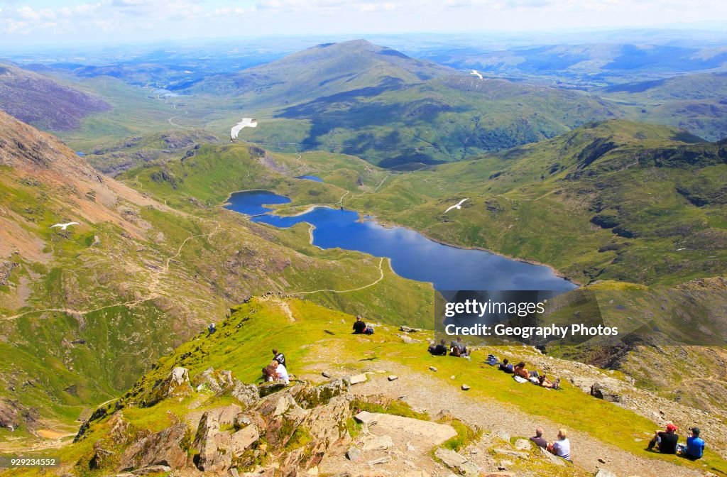 Walkers picnicking Lyyn Llydaw landscape, Mount Snowdon, Gwynedd, Snowdonia, north Wales