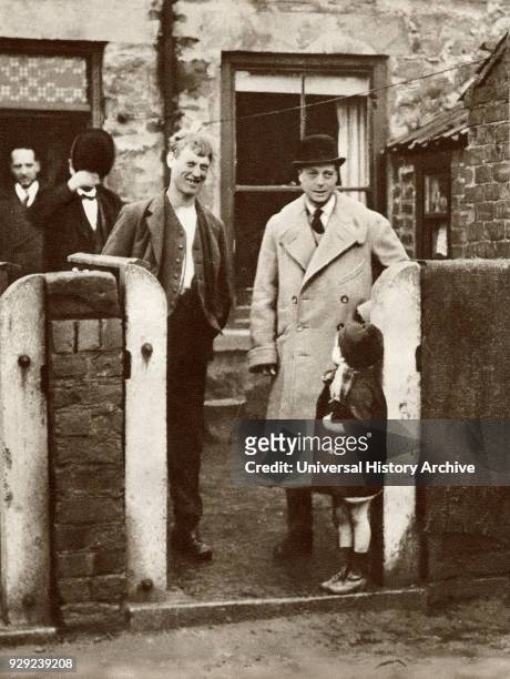 The Prince of Wales, later King Edward VIII visiting a miner's house and family in Durham in 1929. From The Story of 25 Eventful Years in Pictures...