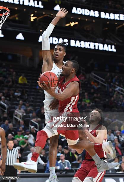 Milan Acquaah of the Washington State Cougars drives to the basket against Kenny Wooten of the Oregon Ducks during a first-round game of the Pac-12...