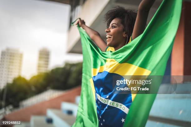 happy brazilian fan watching a soccer game - brazilian flag stock pictures, royalty-free photos & images
