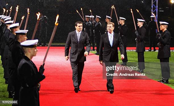 German Foreign Minister Guido Westerwelle and his partner Michael Mronz review an honour guard carrying torches at Bellevue Castle on November 9,...