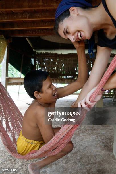 Arrupe Karuna Krom outreach program run by the Catholic church in Battambang, Cambodia. Spanish volunteer with a mentally disabled Khmer boy.
