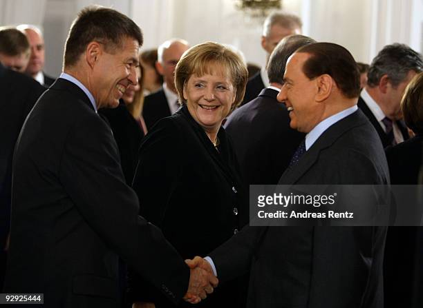 German Chancellor Angela Merkel smiles as her husband Joachim Sauer welcomes Italian Prime Minister Silvio Berlusconi on a reception at Bellevue...