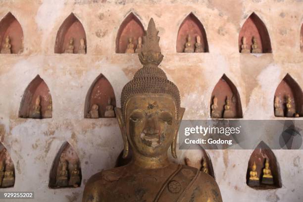 Buddha and pairs of small Buddha statues in the cloister or gallery surrounding the Sim. Part of a collection of approximately 2000 ceramic and...