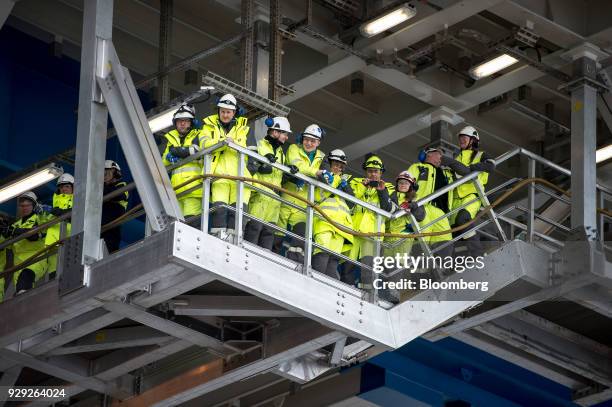 Employees and members of the media stand on a walkway during the ceremonial baptism of the Aasta Hansteen gas platform operated by Statoil ASA near...