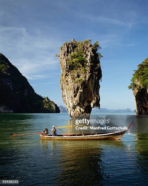 long tail boat on rocky seascape, ko tapu, thailand - james bond island stock pictures, royalty-free photos & images