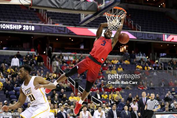 Trey Landers of the Dayton Flyers dunks over Khris Lane of the Virginia Commonwealth Rams in the first half during the second round of the Atlantic...