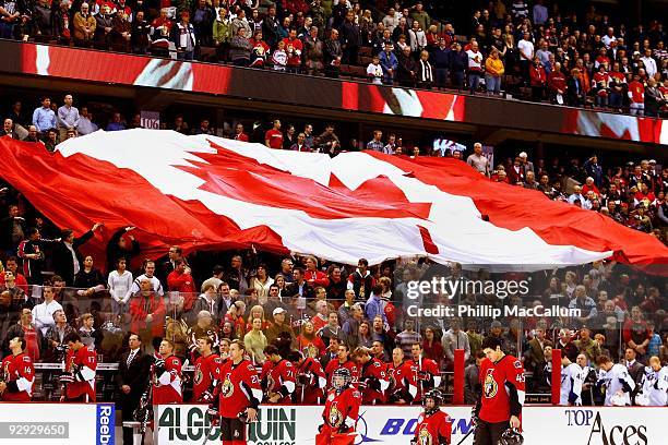 The fans at Scotiabank Place pass around a giant Canadian Flag through the stands during the national anthem before a game between the Tampa Bay...