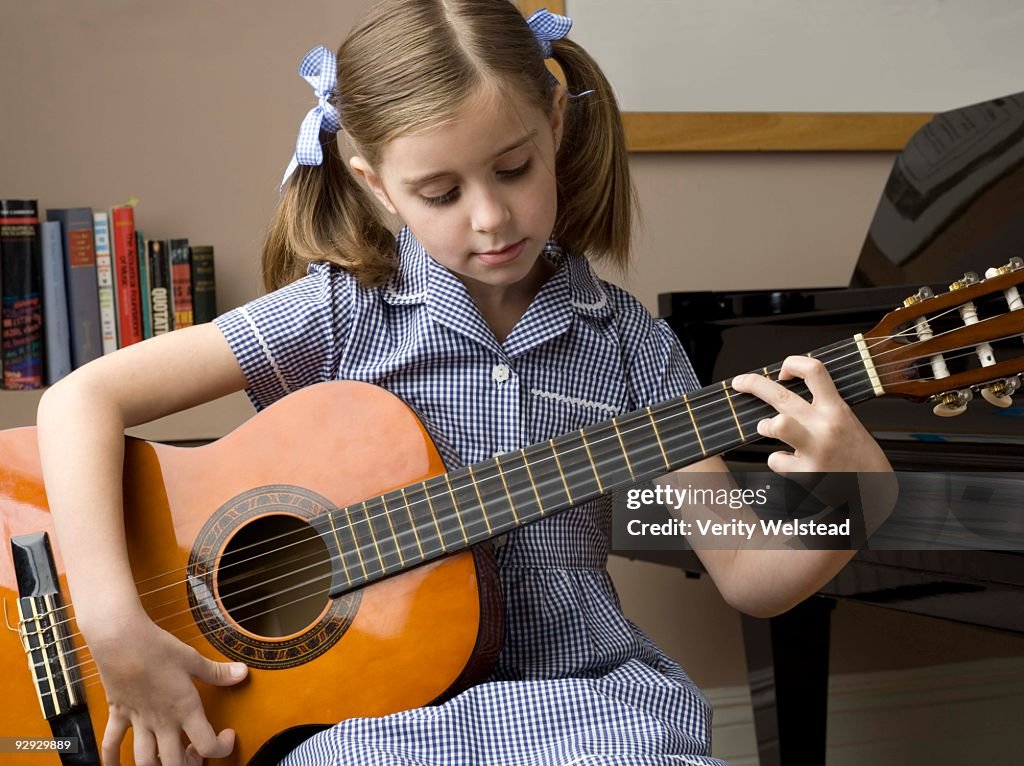 Girl practicing on guitar