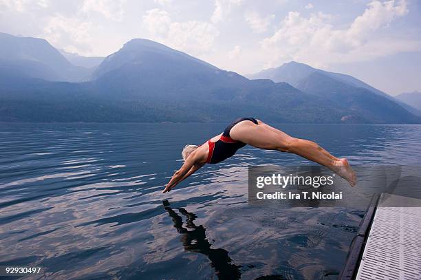 female babyboomer diving into lake - dove imagens e fotografias de stock