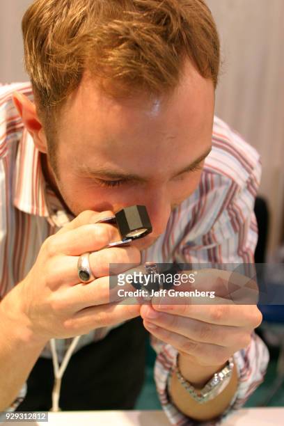 Gemologist examines an Alexandrite ring at an Antique Show.