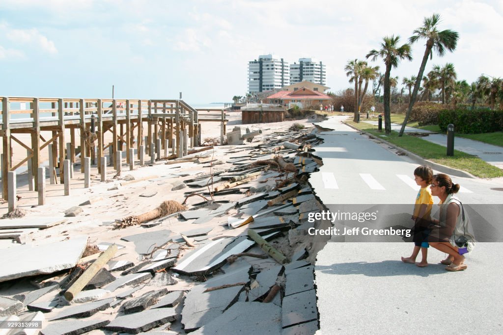 A mother and son looking at the missing road at Vero Beach damaged by Hurricane Jeanne.